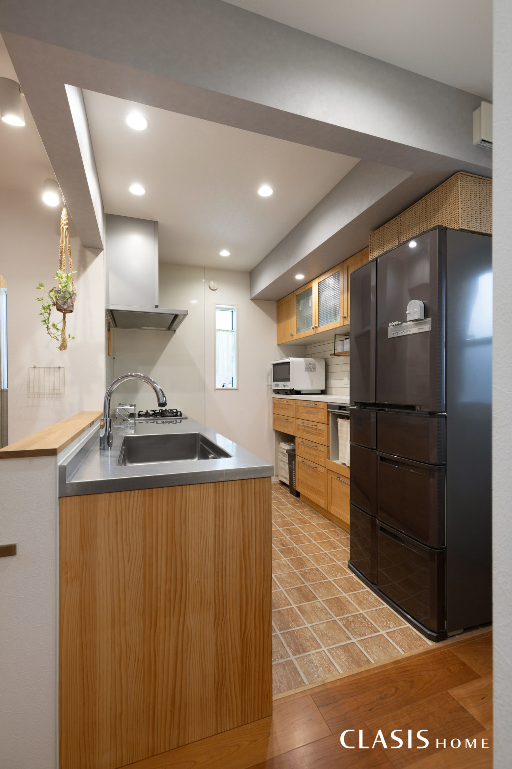 無垢材を使用したキッチンと、温かみのあるタイルでカントリー調のキッチンスペース。