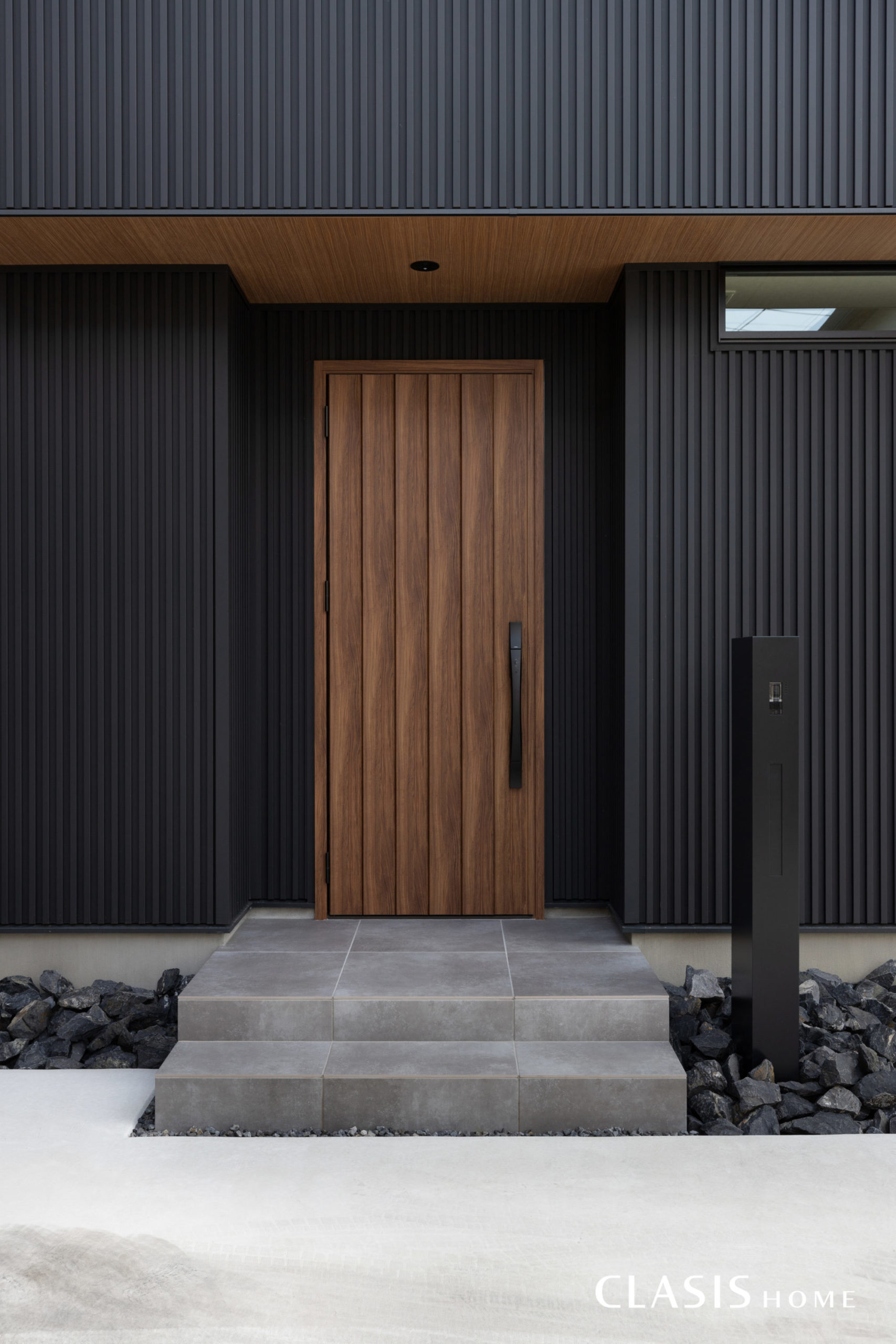 黒のガルバリウム鋼板によく合う、木目の玄関。