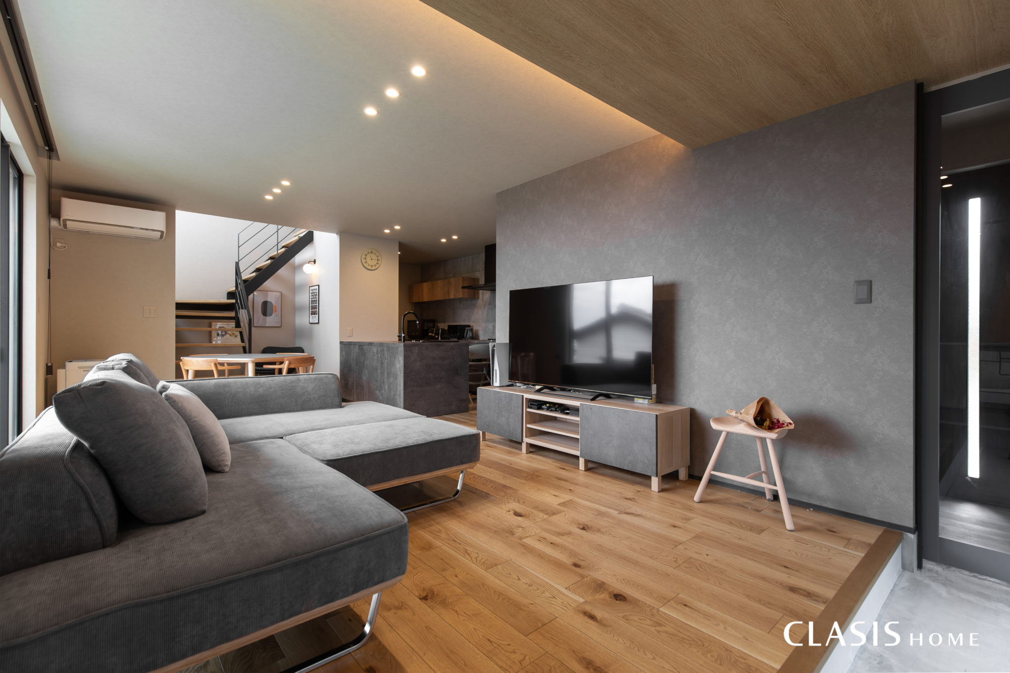 スモーキーなグレーの家具やクロスにオークの床材が上質な印象のLDK。