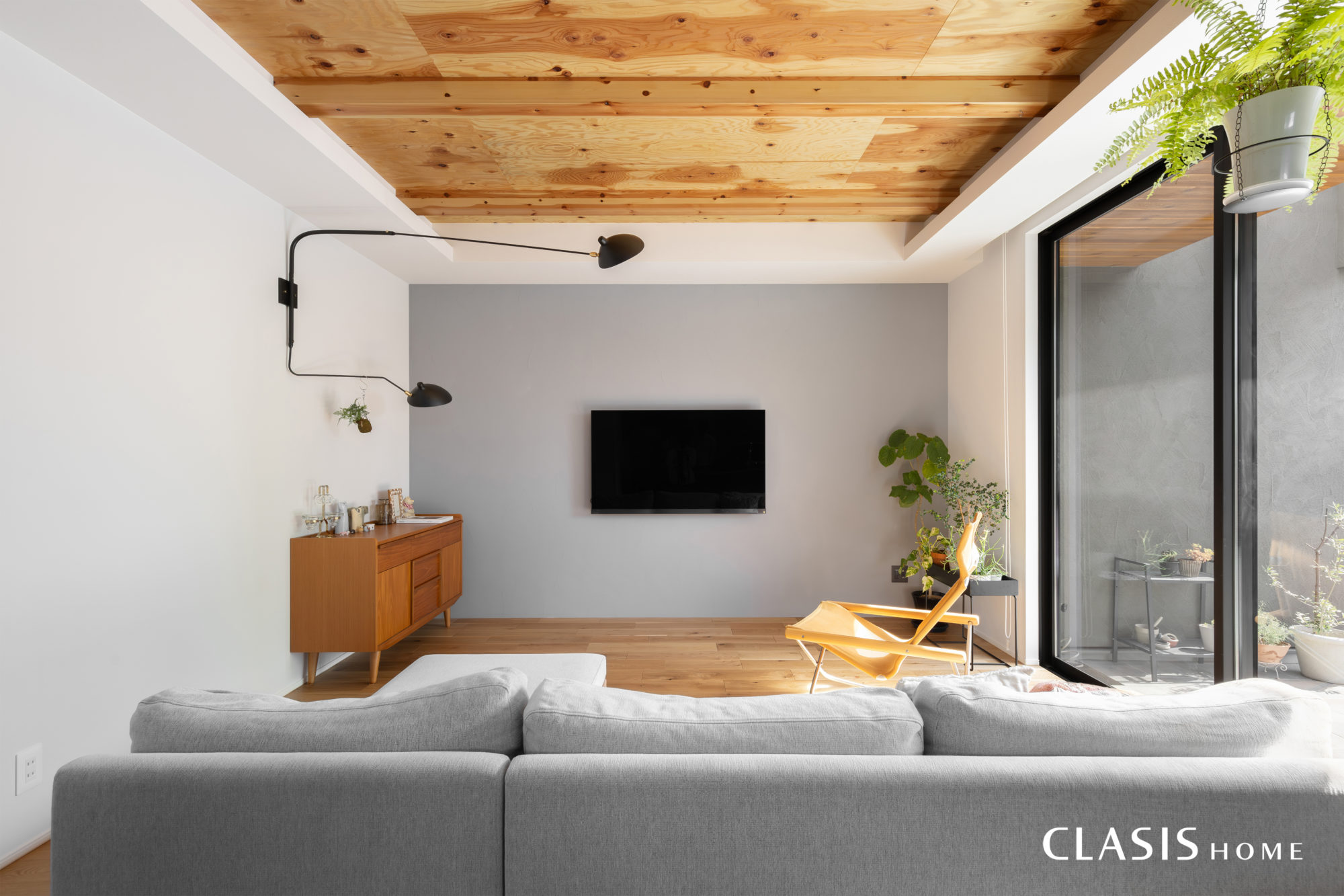 針葉樹合板の天井が特徴の自然素材に囲まれるリビング
