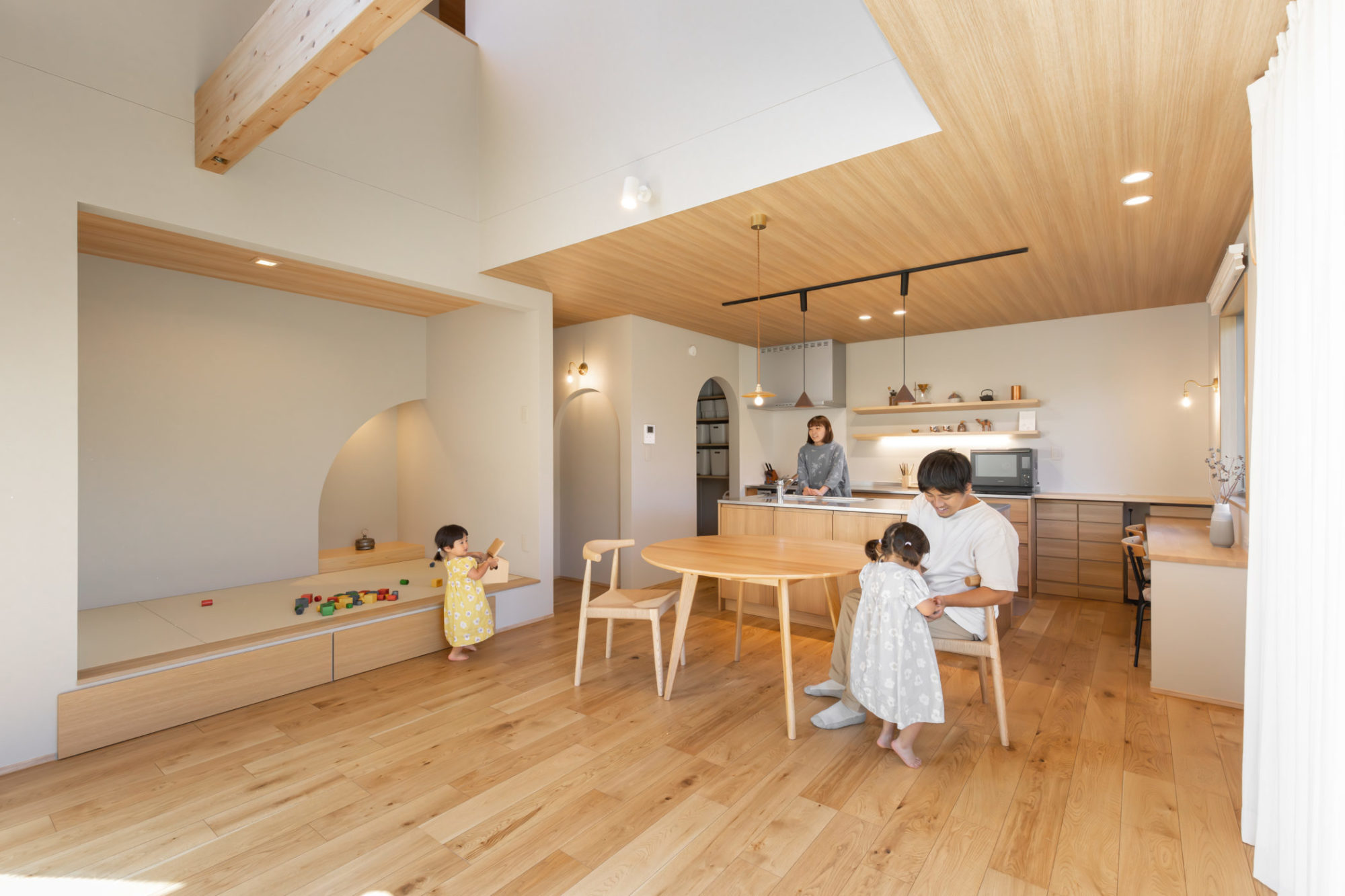 グレージュと木目でまとめたナチュラルなLDKで過ごす家族団らんの写真