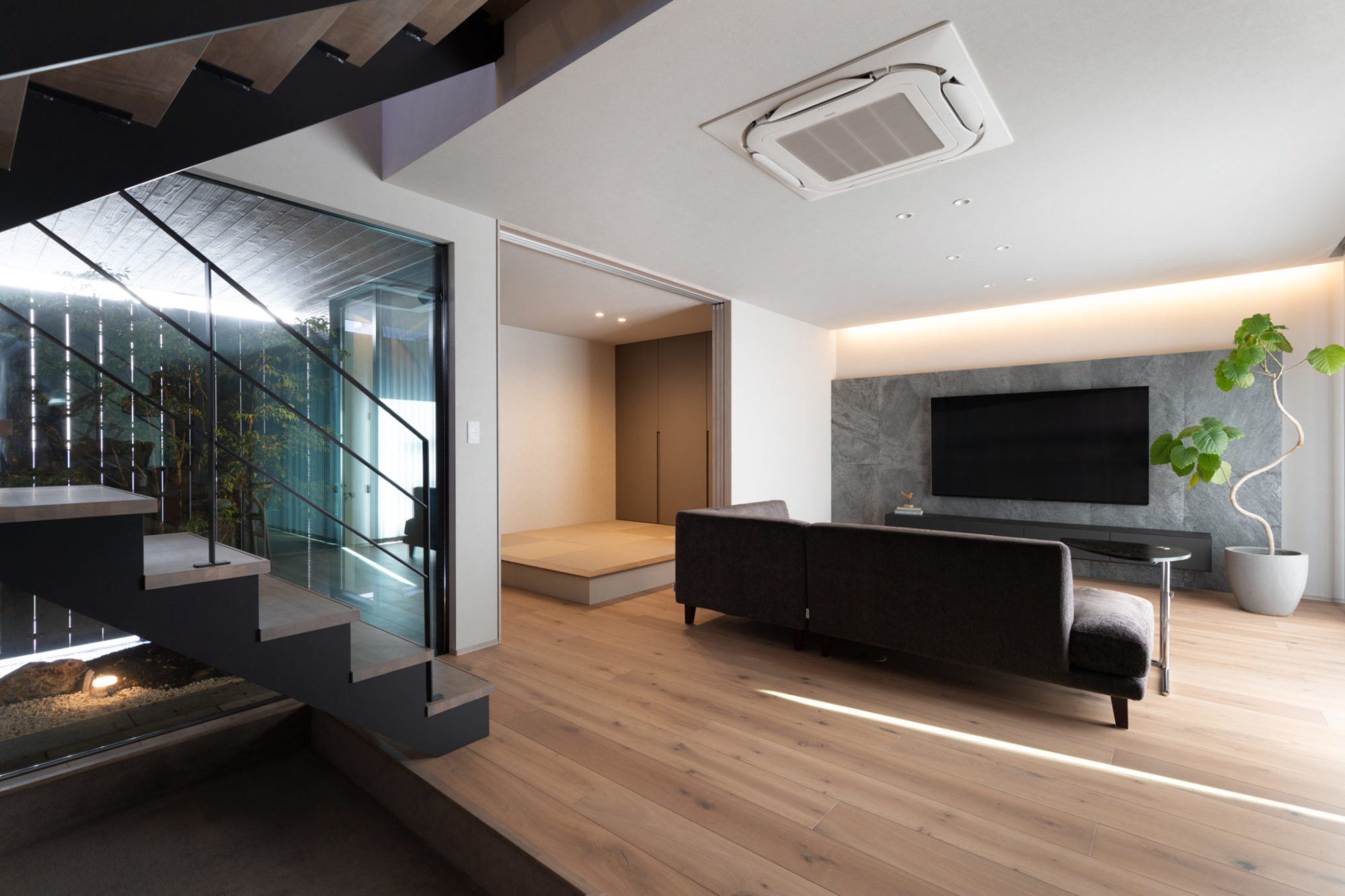 中庭と坪庭が見えるリビングと個室として使える扉付き小上がり和室の写真