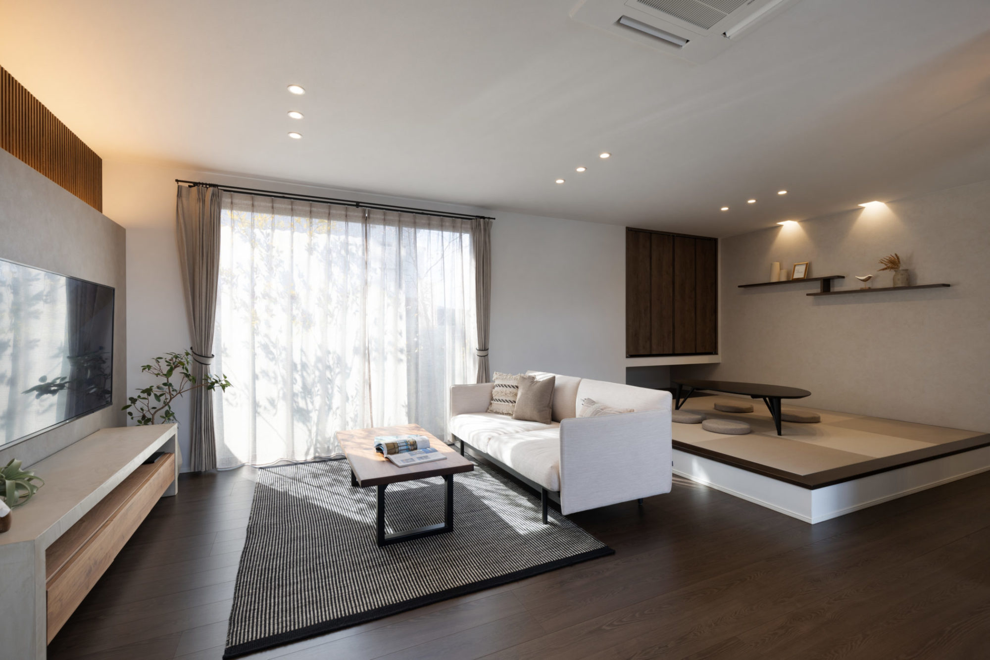 グレーベースのモダンな小上がり和室とリビングの写真