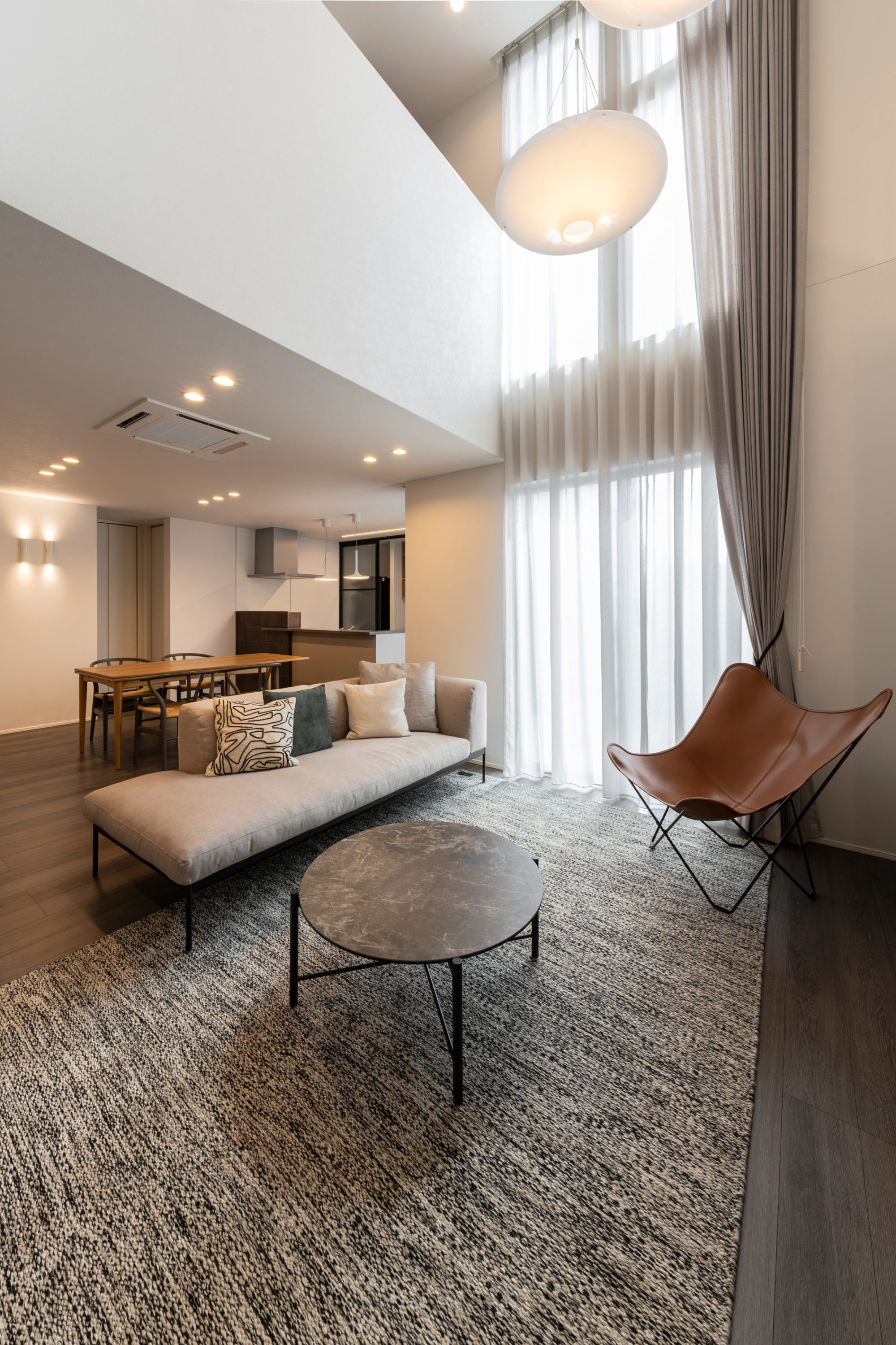 吹き抜けを設け、縦方向に広がりを感じられるリビング。