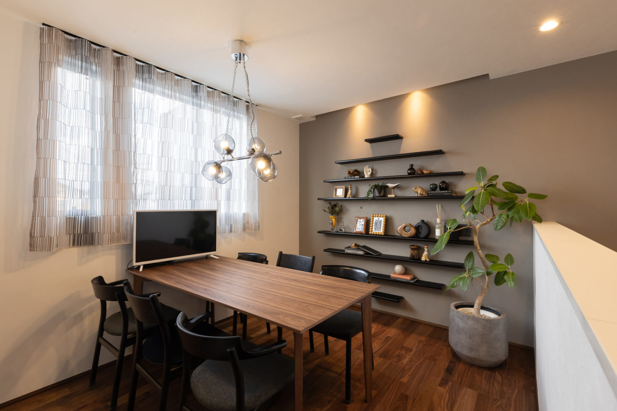 ウォールナットの突板をランダムピッチで張った2階ホール。ブラックをアクセントに効かせ、少しアメリカンなテイストを意識したコーディネート。