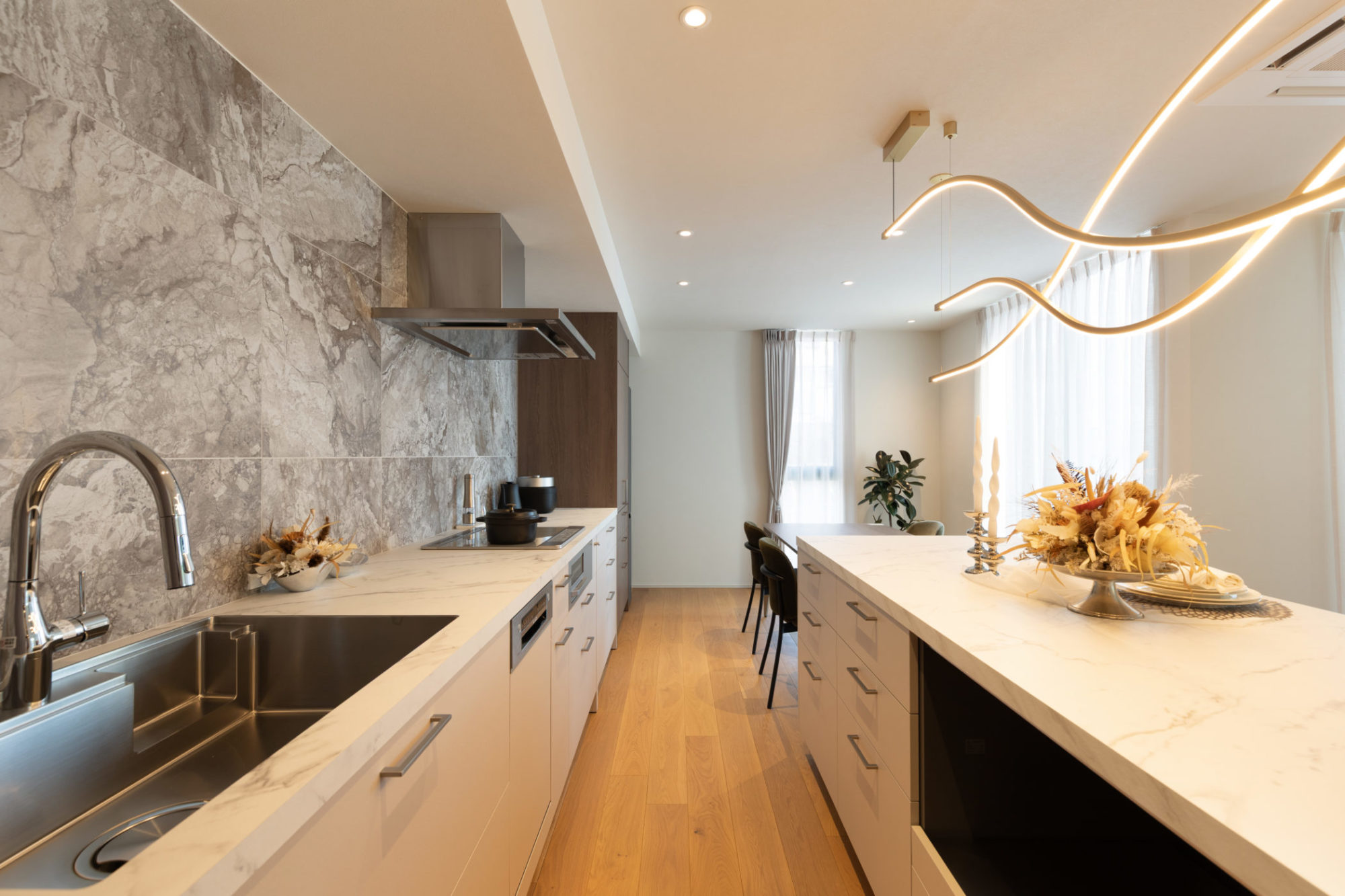 キッチン・ダイニングの写真｜石模様タイルと大理石調ワークトップで高級感を演出