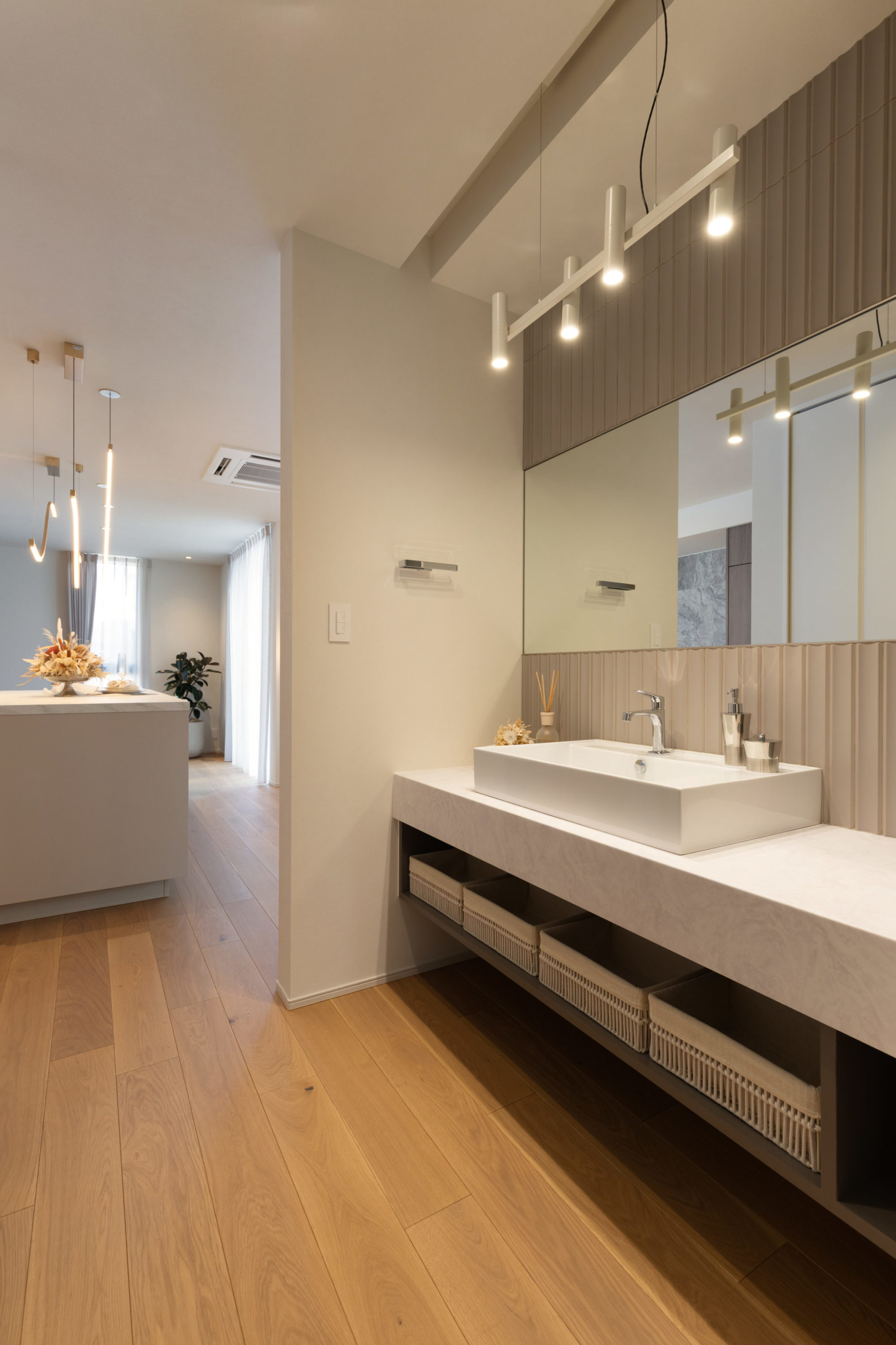 洗面台の写真｜奥に見えるキッチンと石目の色味を統一した施工事例