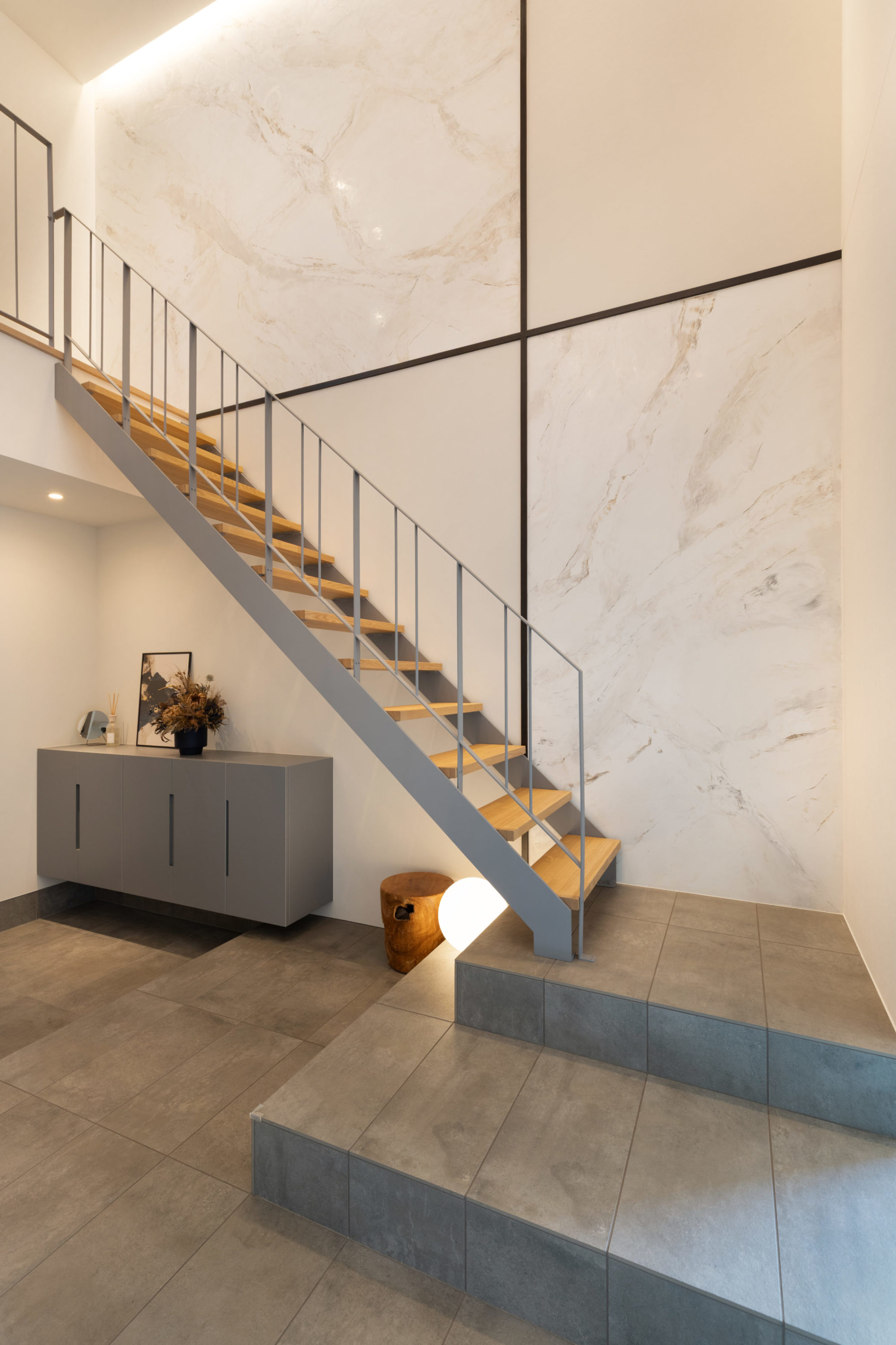 玄関ホールの写真｜スケルトン階段と大理石調塗装のアクセントウォール