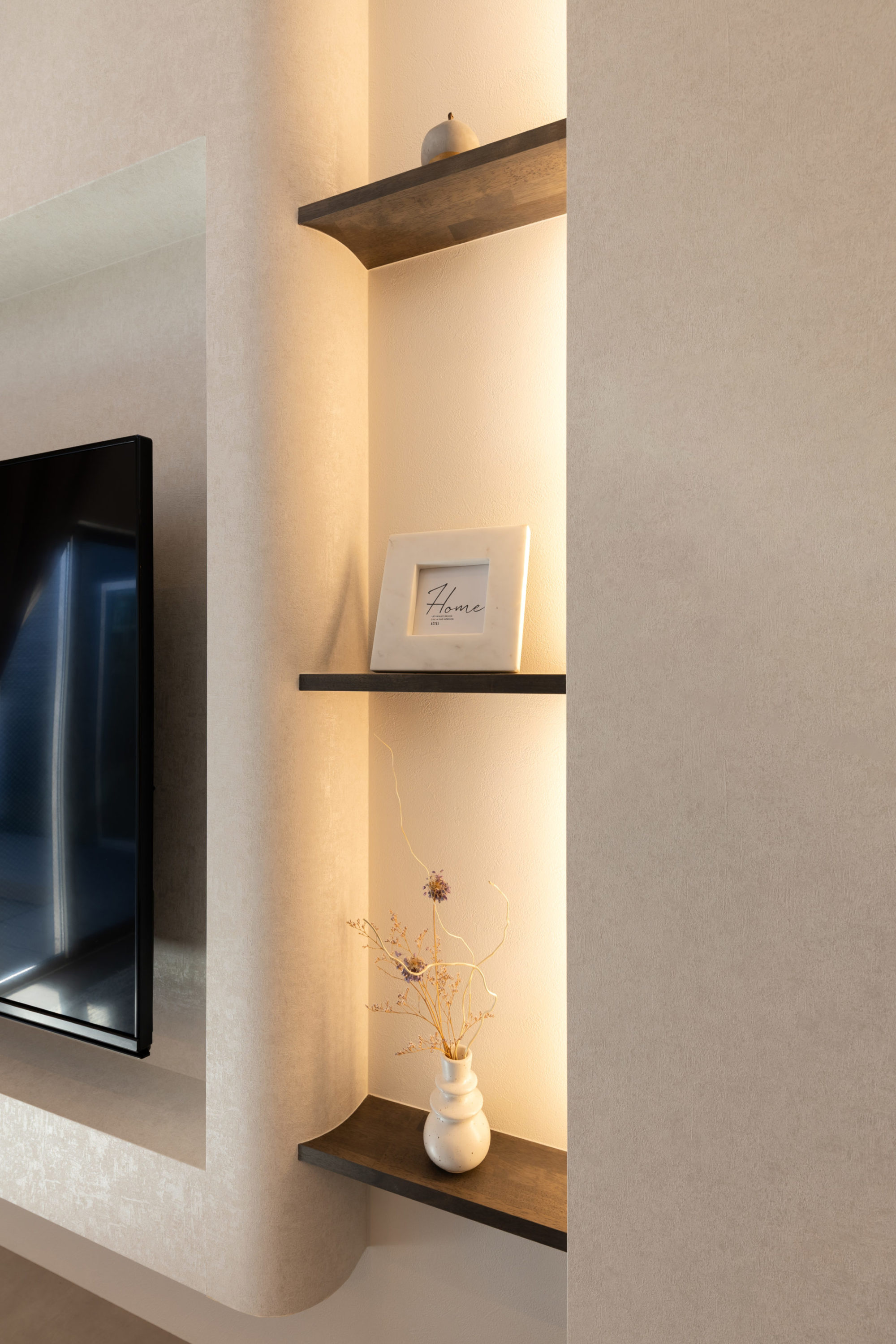 テレビ横に配置した飾り棚。間接照明を仕込み、上質な雰囲気を演出。