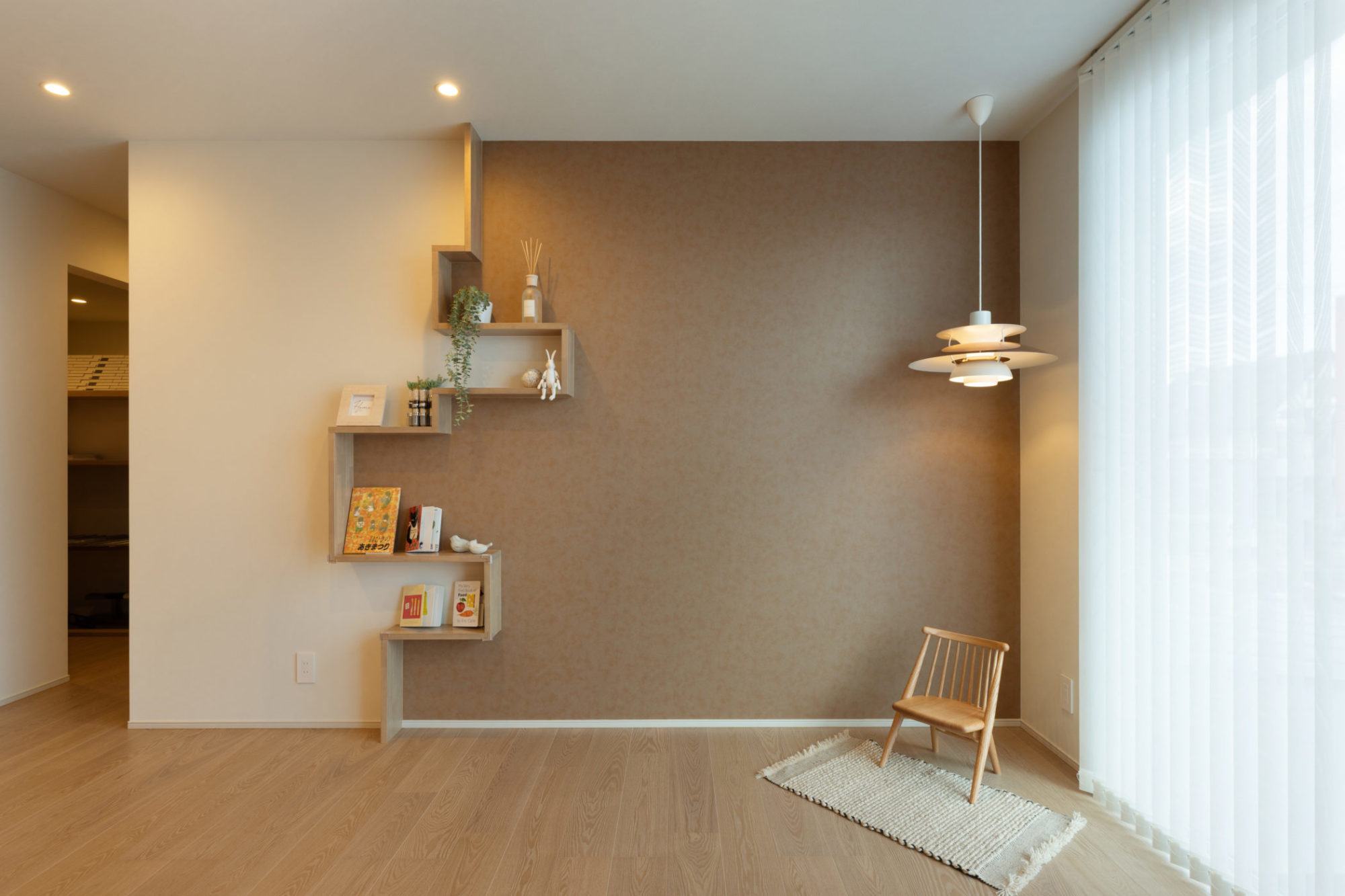 2階フリースペースの写真｜凹凸のある壁面飾り棚とレザー調クロスで空間に動きをプラス