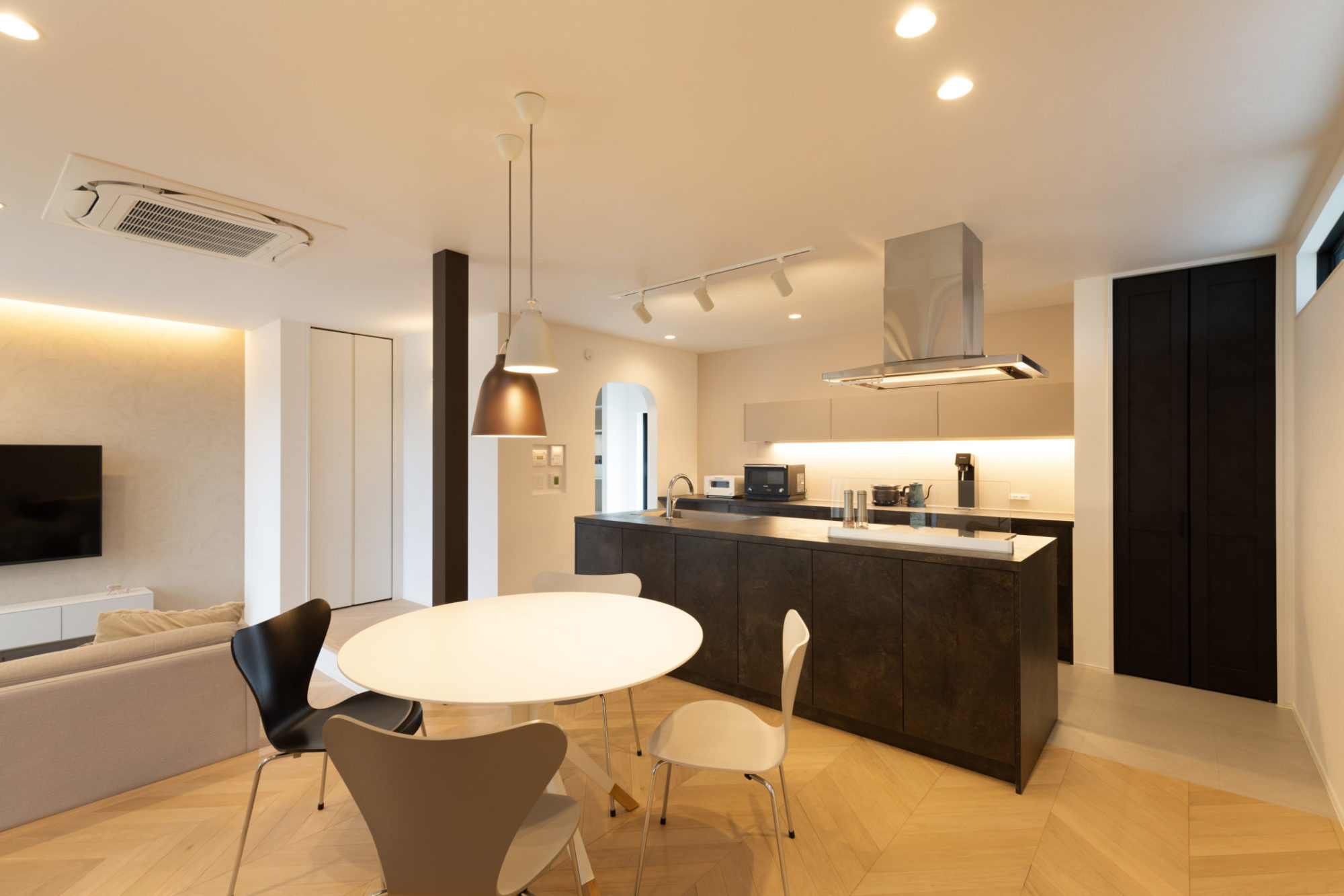 グレージュの色味やヘリンボーン貼りのオークの床材が暖かみを感じるLDK。