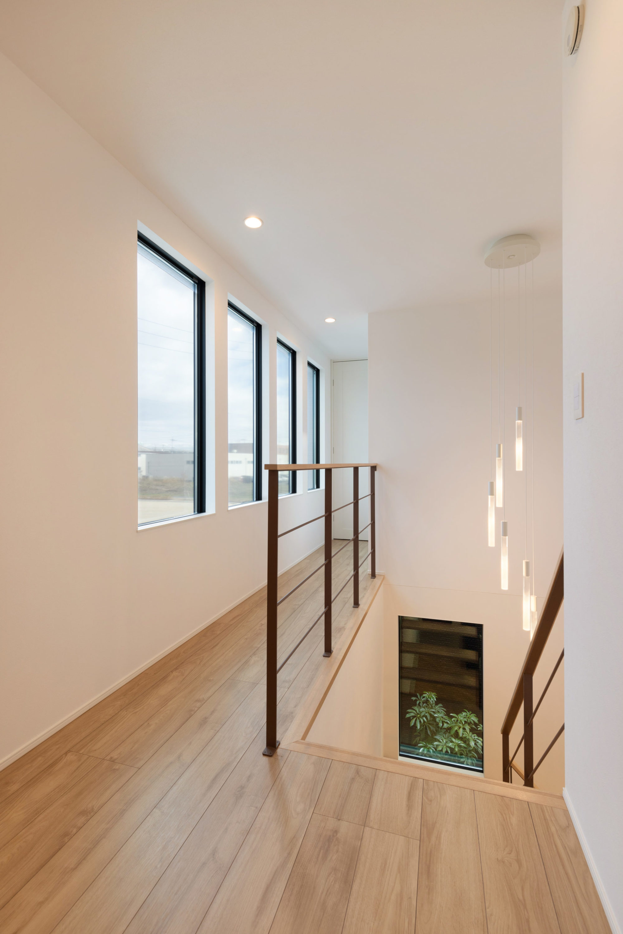 4つ並んだ窓と鉄骨手摺で視線の抜けを生む開放的な2階ホール。