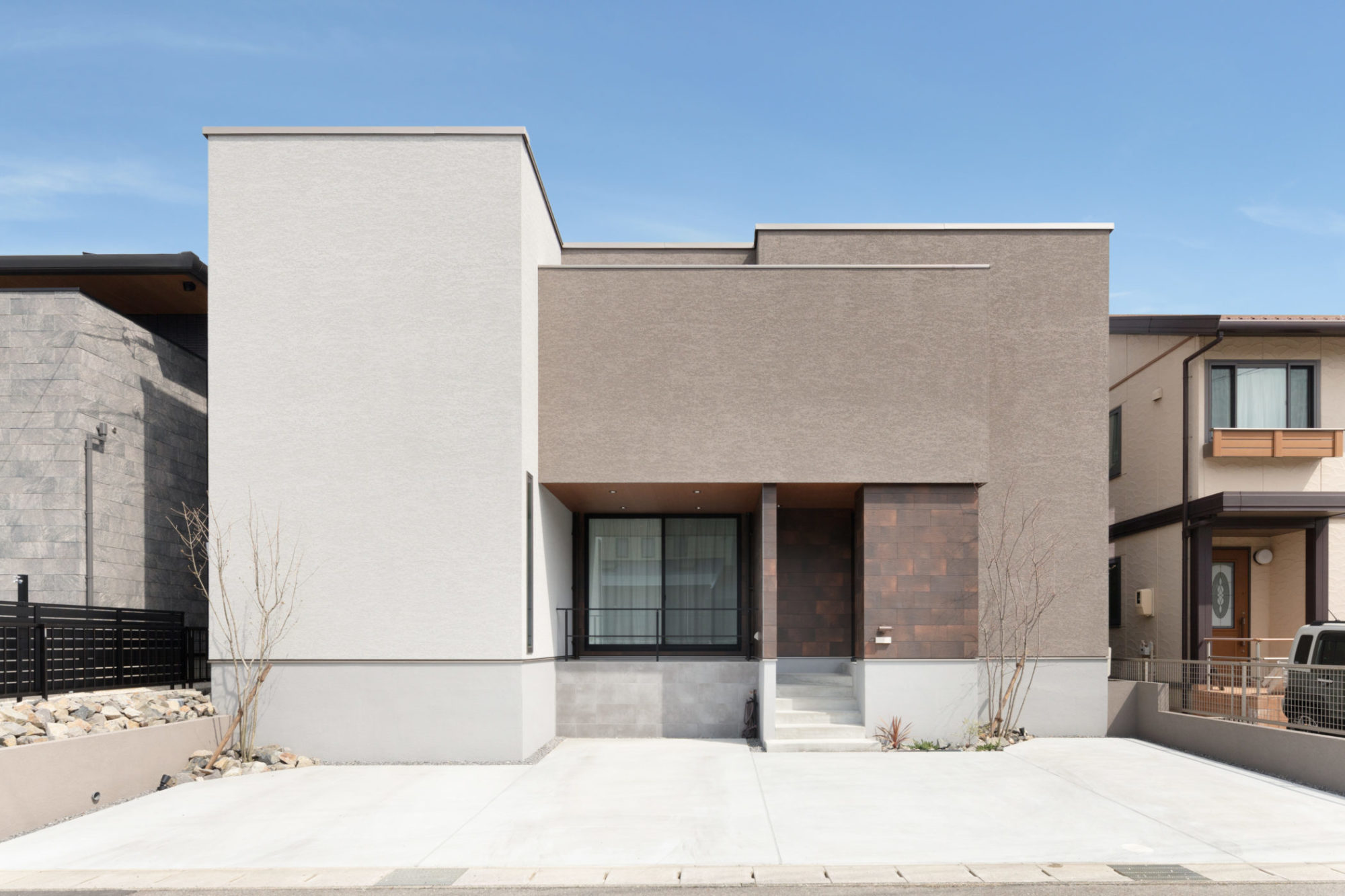 2色の塗り壁と錆色のアクセントタイルを採用した立体感のある外観。