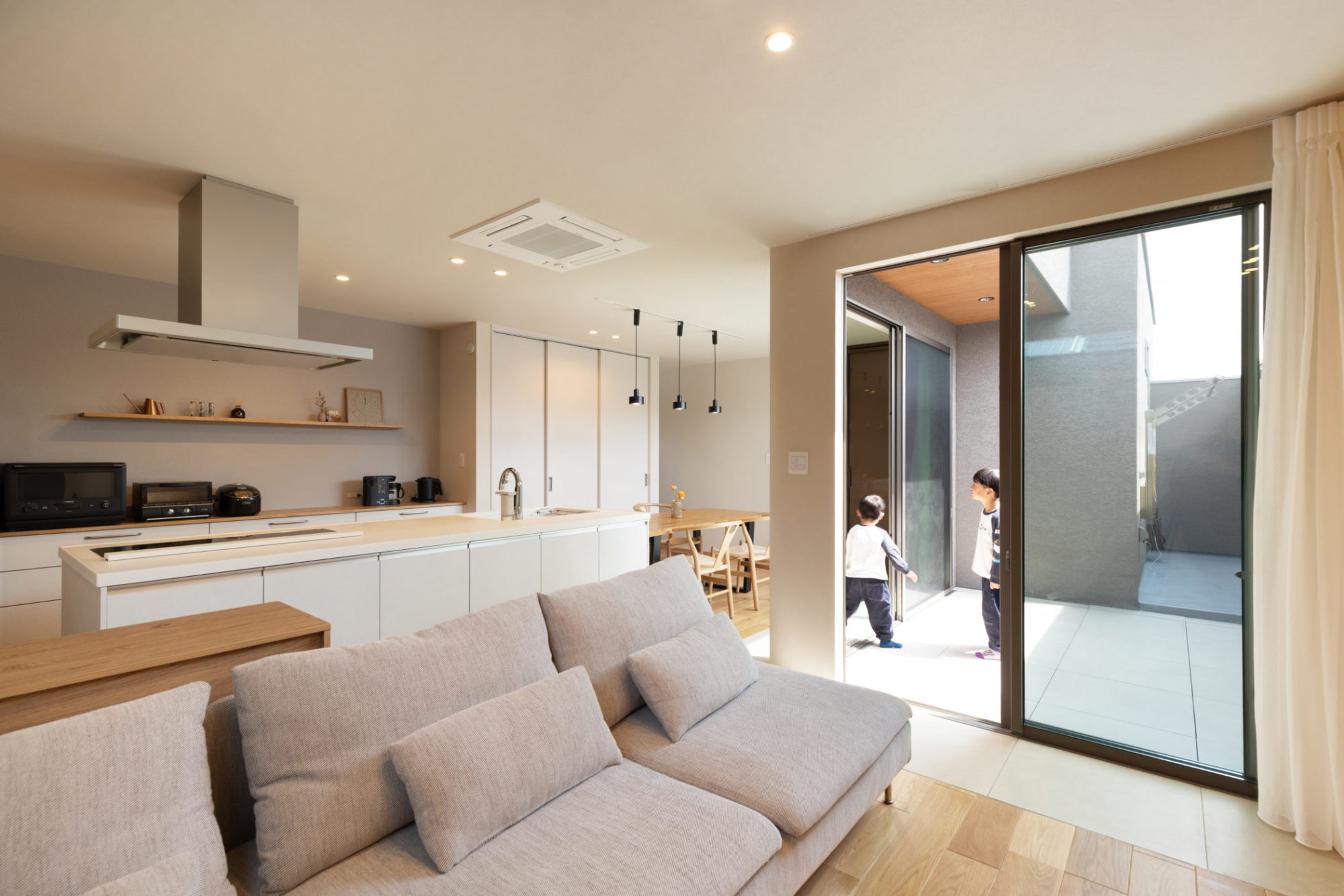 バルコニーに面してL字型に配置した2階LDK。床をフラットにつなげ、広々とした空間を実現しました。