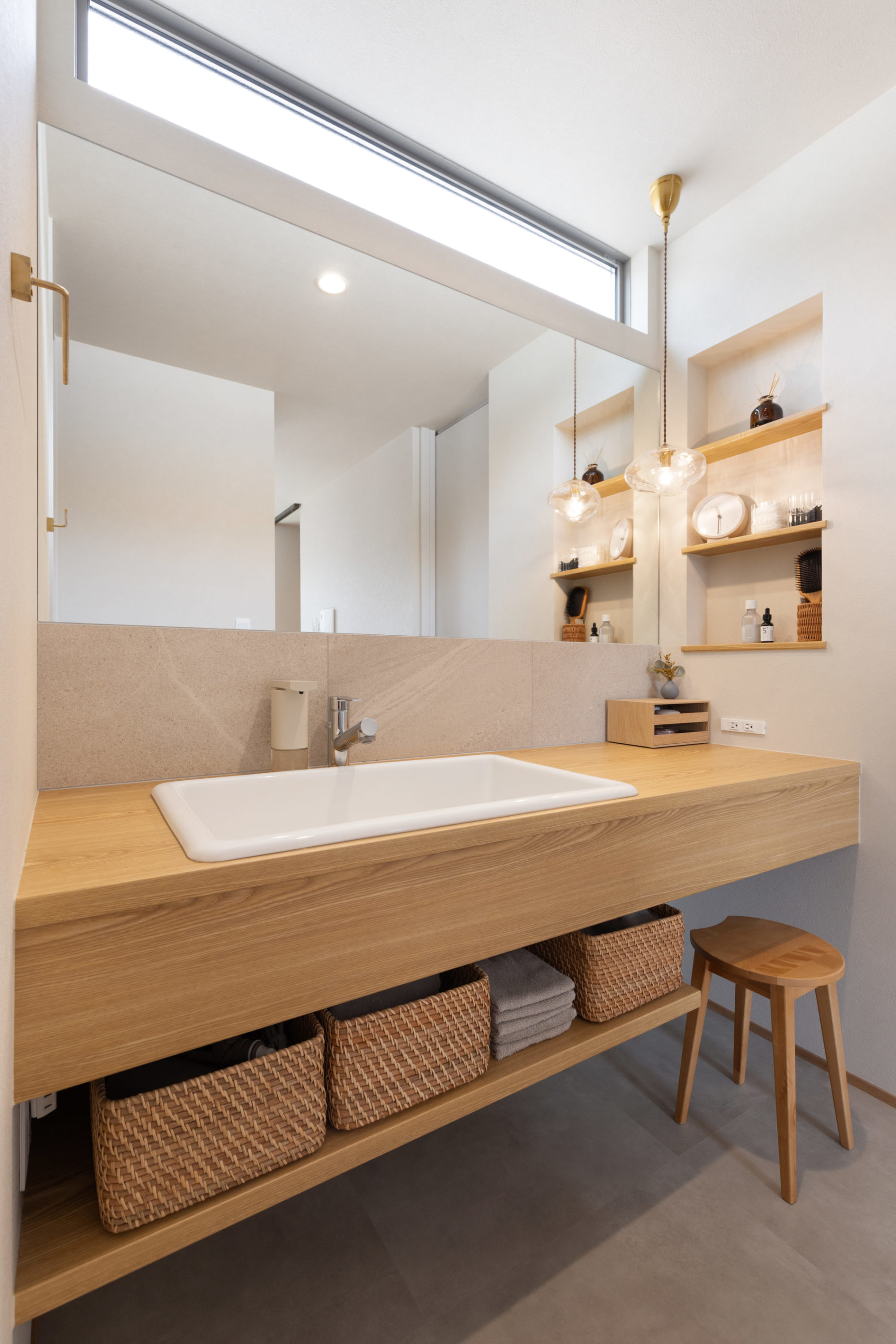 木目とベージュのタイルを取り入れた造作洗面台。広い洗面ボウルを採用し使い勝手も抜群。