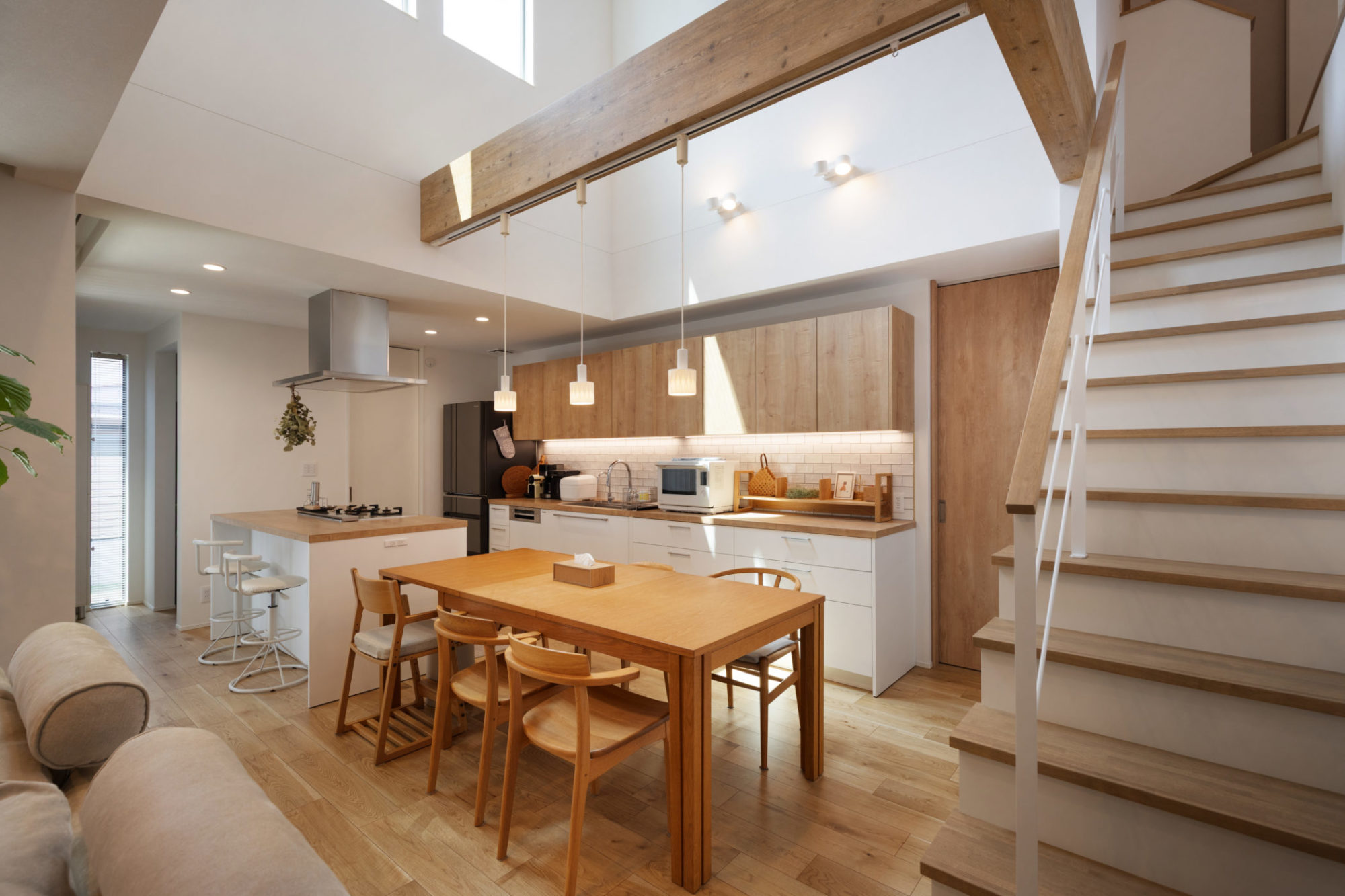 白と木目調でまとめたⅡ型キッチンとダイニング空間