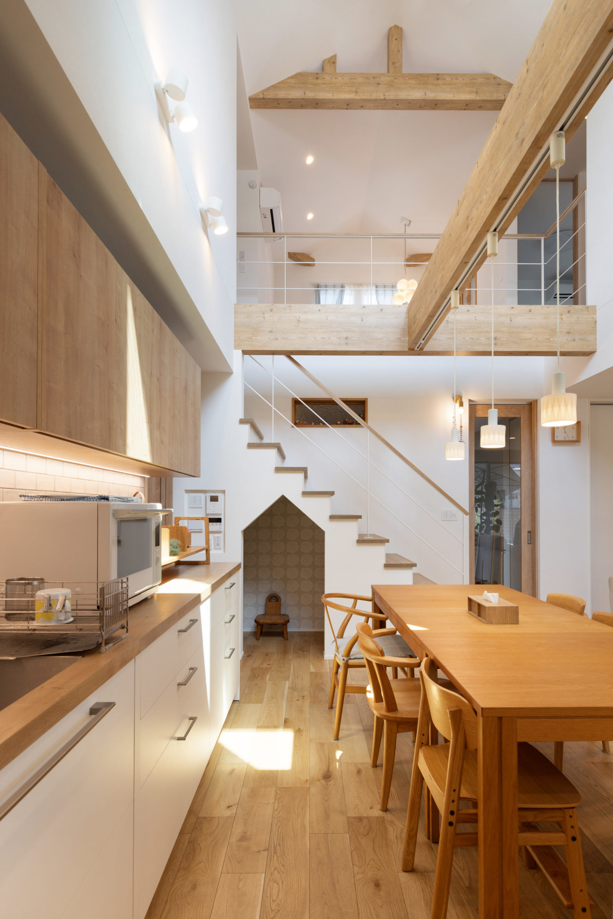 吹き抜けダイニングに化粧梁を設け、ペンダントライトが映える空間