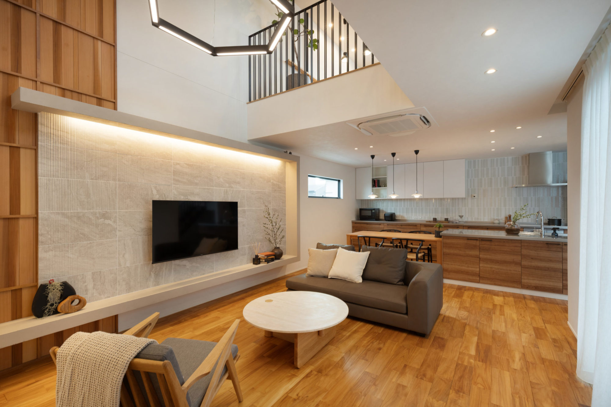 チークの無垢床と白い壁がメリハリを生む、シックなテイストのLDK。大きな吹き抜けを設けた開放的な大空間。