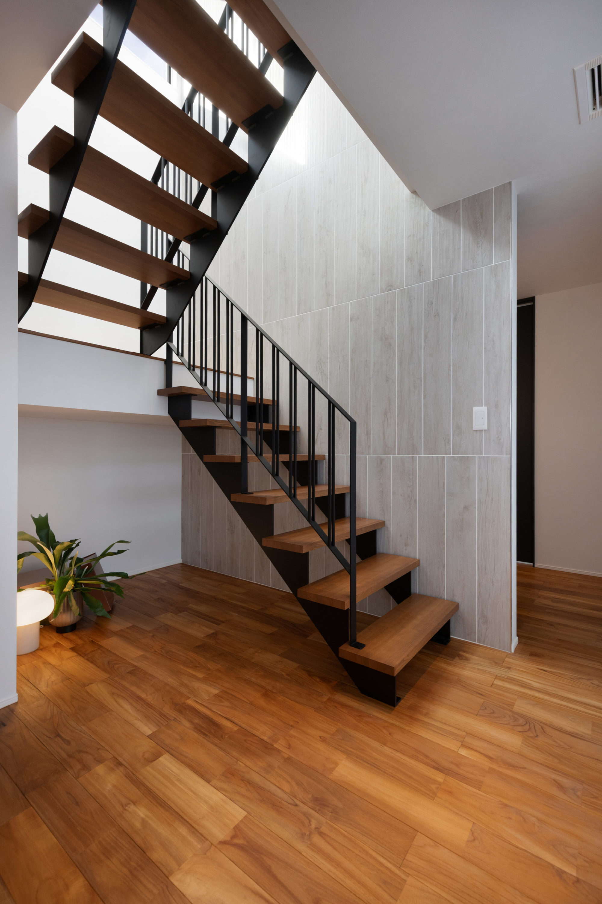 外部用タイルをあえて採用し、目地をずらしてリズムを生み出した階段の壁面。近代建築の意匠から着想を得た繊細な手摺が印象的。
