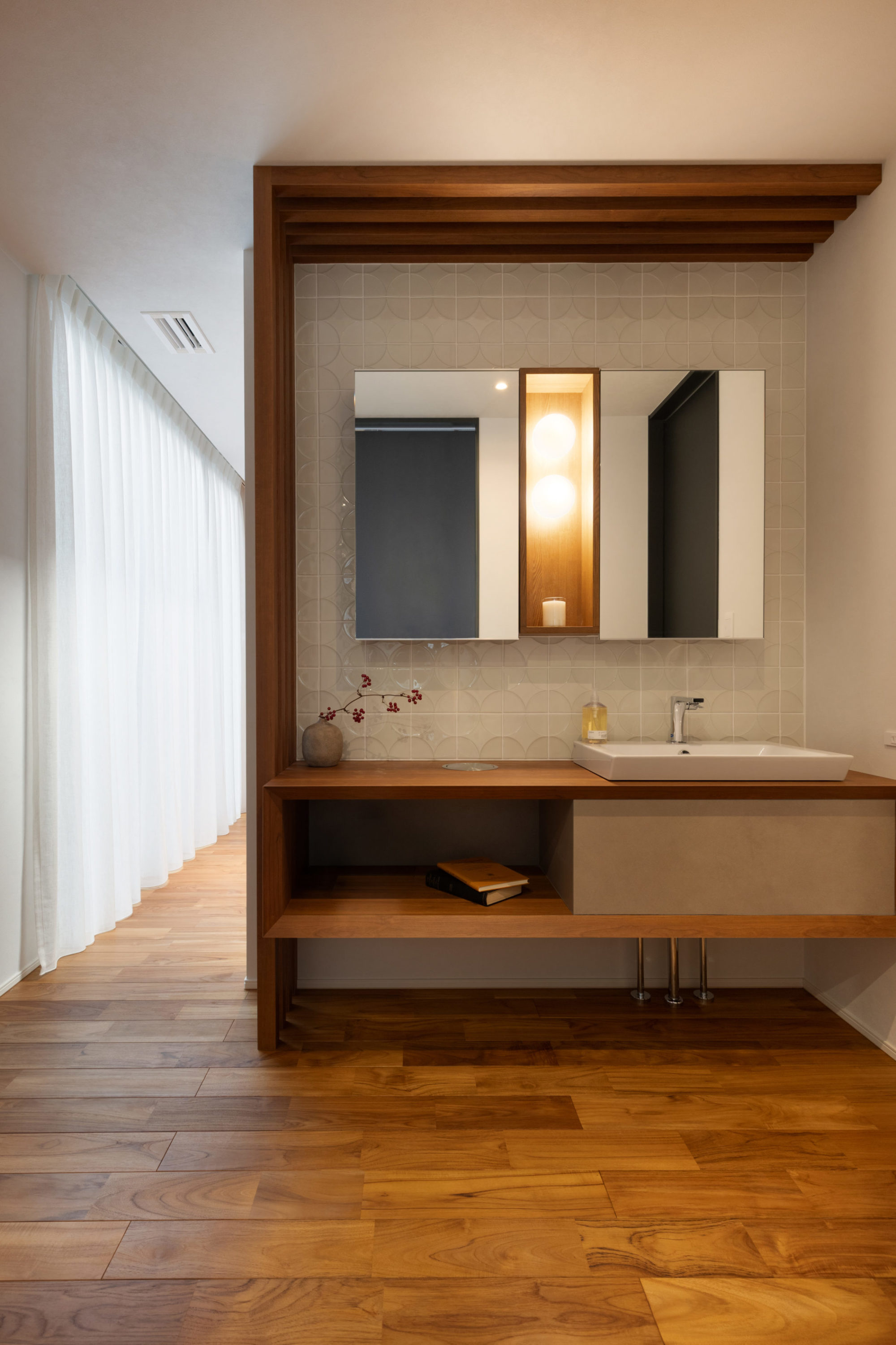 L字のルーバーと個性的なタイルが目を引く造作洗面台。