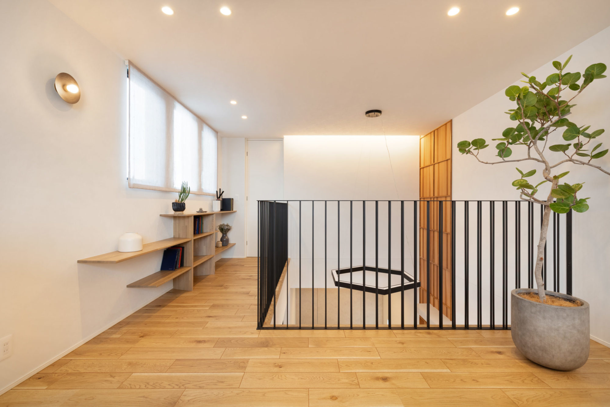 リビングの吹き抜け上部とつながる2階ホール。挽板のような質感をもつ突板の床材を採用。